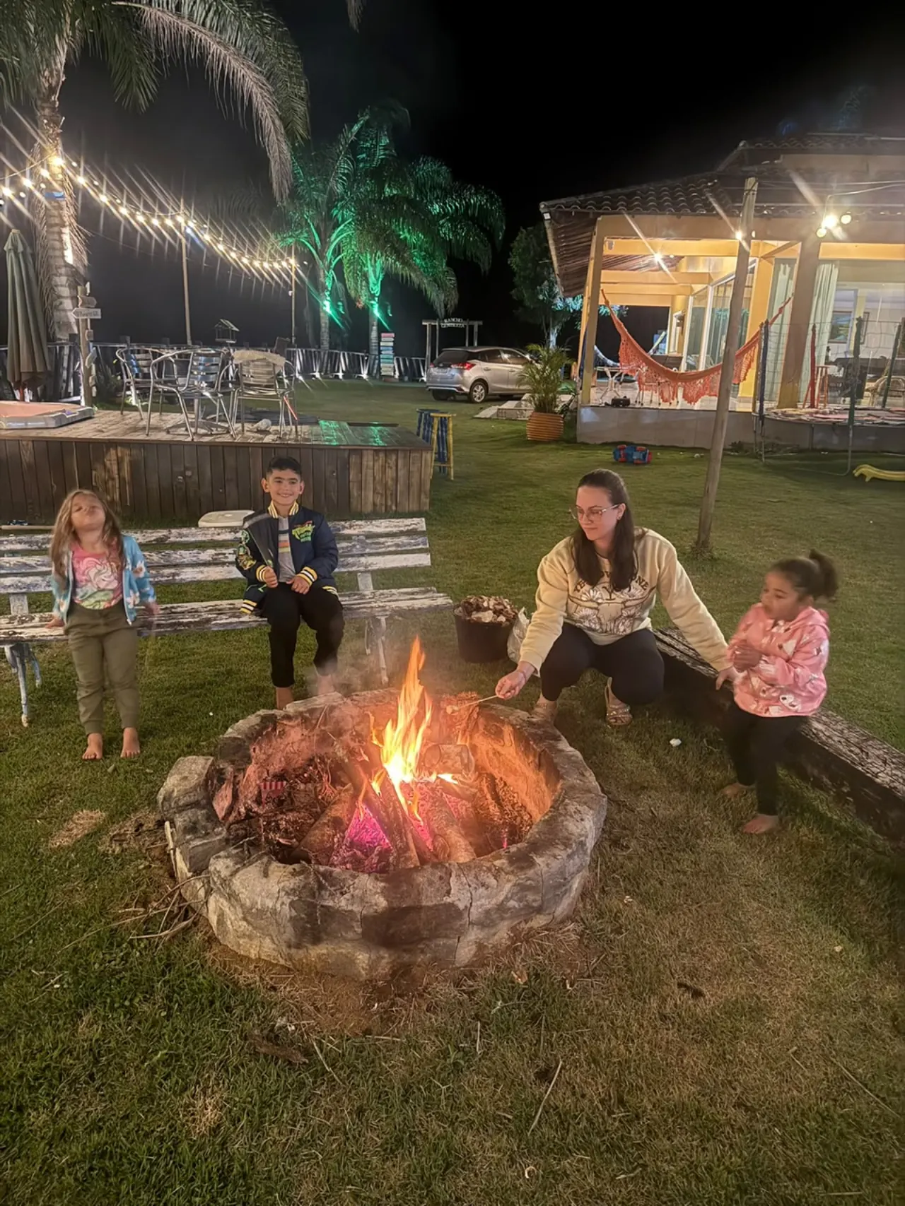 Crianças assando marshmallow ao redor da fogueira