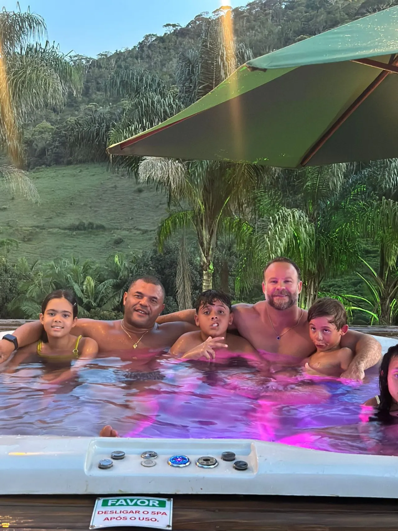 Família na jacuzzi com vista para a serra